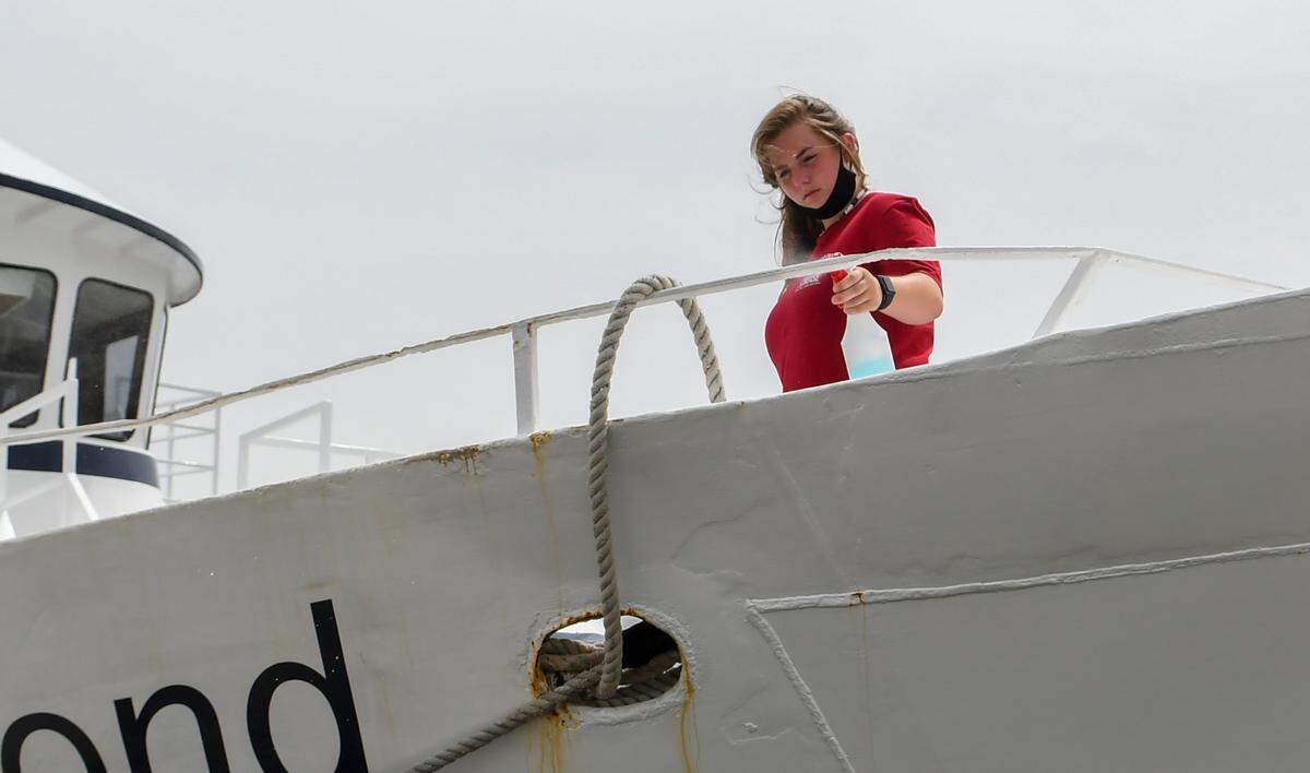 An employee with The Vagabond Cruise sanitizes touch points on Saturday, June 27, 2020 at Harbour Town in Sea Pines on Hilton Head Island after a sight seeing group on the vessel returned to the pier.