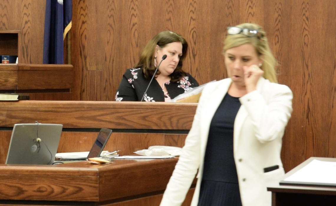 S.C. Law Enforcement Division analyst Katie Corley, left, looks to verify the evidence of Isaiah Gadson Jr’s buccal swabs she tested as prosecutor Hunter Swanson returns to her desk.