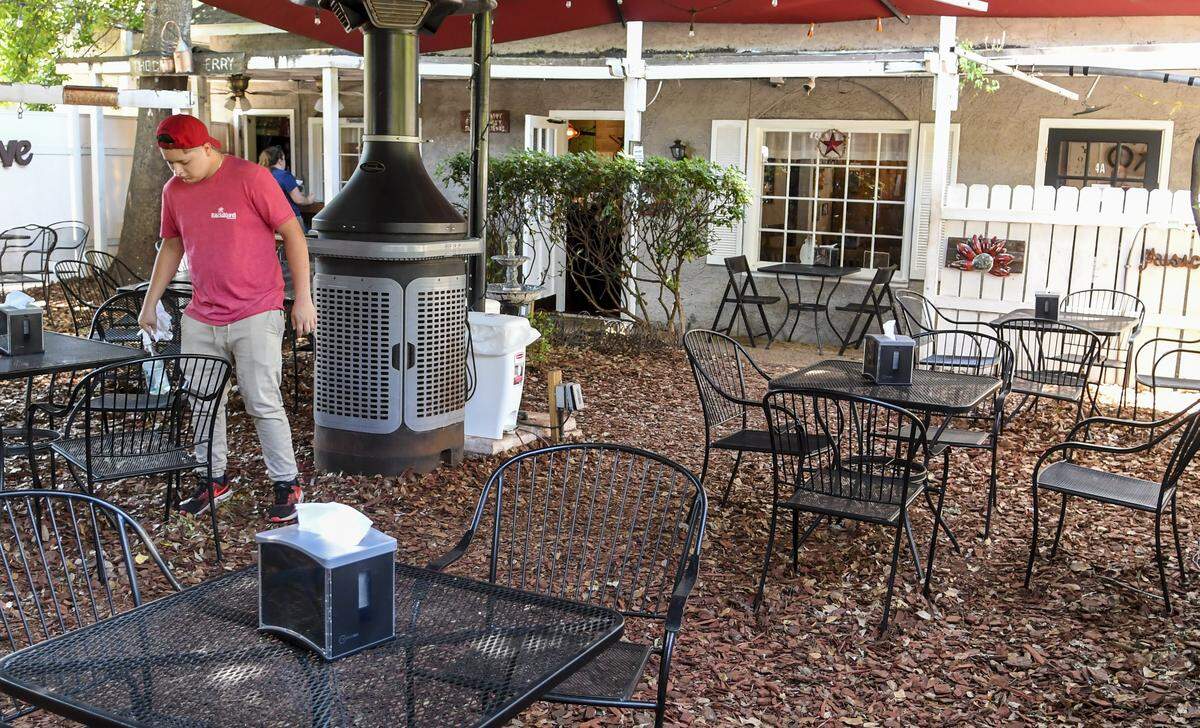 Pedro Ponce sanitizes the chairs and tables after patrons finished their meal on the patio at Backyard Restaurant on Monday, May 11, 2020 on Hilton Head Island. Monday marked the first day restaurants could have indoor seating at half the capacity after SC Governor Henry McMaster relaxed some of the rules on closures he enacted to stop the spread of the coronavirus.