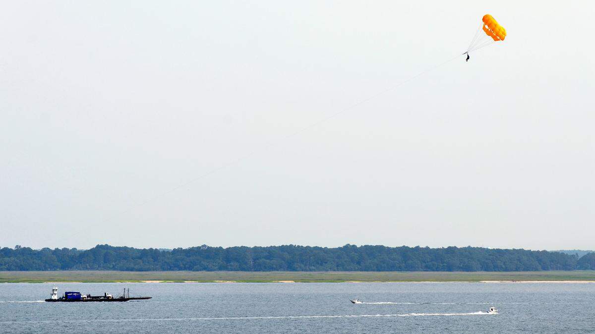 Water traffic on Calibogue Sound, including a parasailer, passes off the wooded shore of Bull Island on Wednesday in this view taken from atop the Harbour Town Lighthouse.