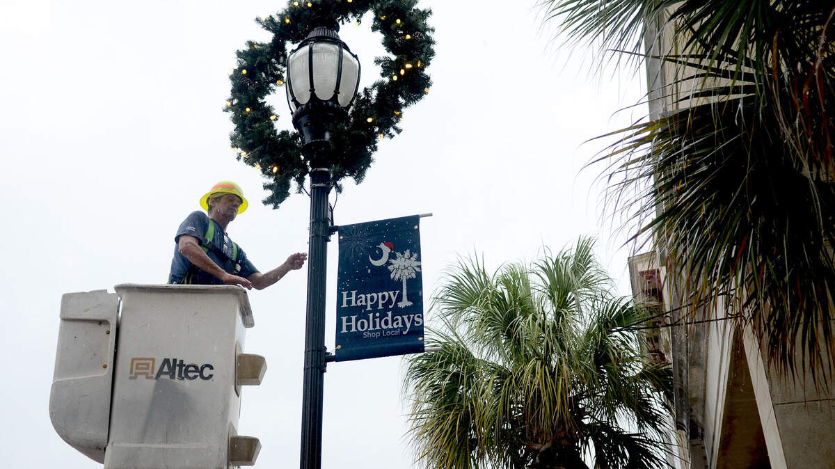 Frank Mueller, maintenance traffic control supervisor with the City of Beaufort Public Works, checks to make sure the lights work on one of the 26 wreaths being installed on the light poles along Bay Street on Nov. 2, 2015, in downtown Beaufort. This is the first year that the wreaths have been used as decorations on the poles.