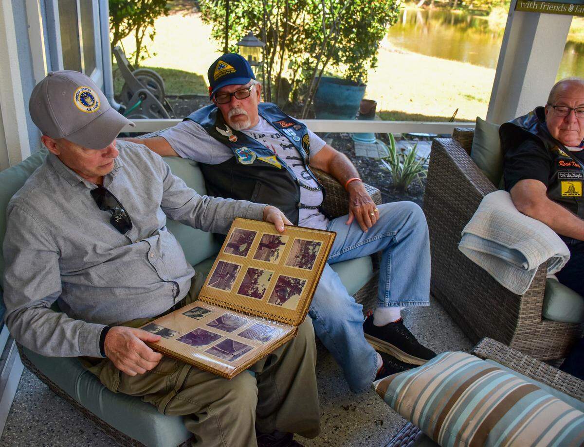 Dave Dence, left, shares pictures from his military days, while Gary Hohman, and Jon Watkins, look on. All three men are active members of the South Carolina Patriot Guard Riders, a national 501(c)3 non-profit organization founded in 2005 that shows respect to the families of the military, veterans and first responders that have died and shield families from interruptions from protesters.