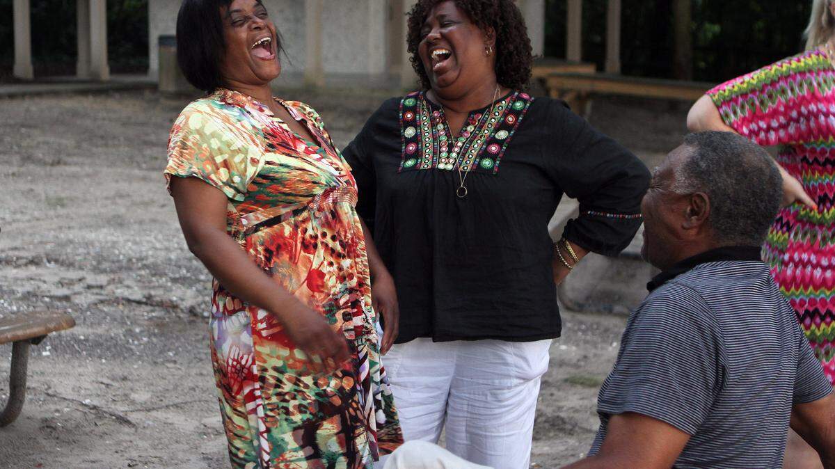 Renea Frazier, wife of the late Oscar Frazier, center, laughs with longtime friends Juanita Cleveland, left, and Jacob Martin, both of Bluffton, during the second annual event to honor Oscar Frazier on Sept. 4, 2015, at Oyster Factory Park in Bluffton.