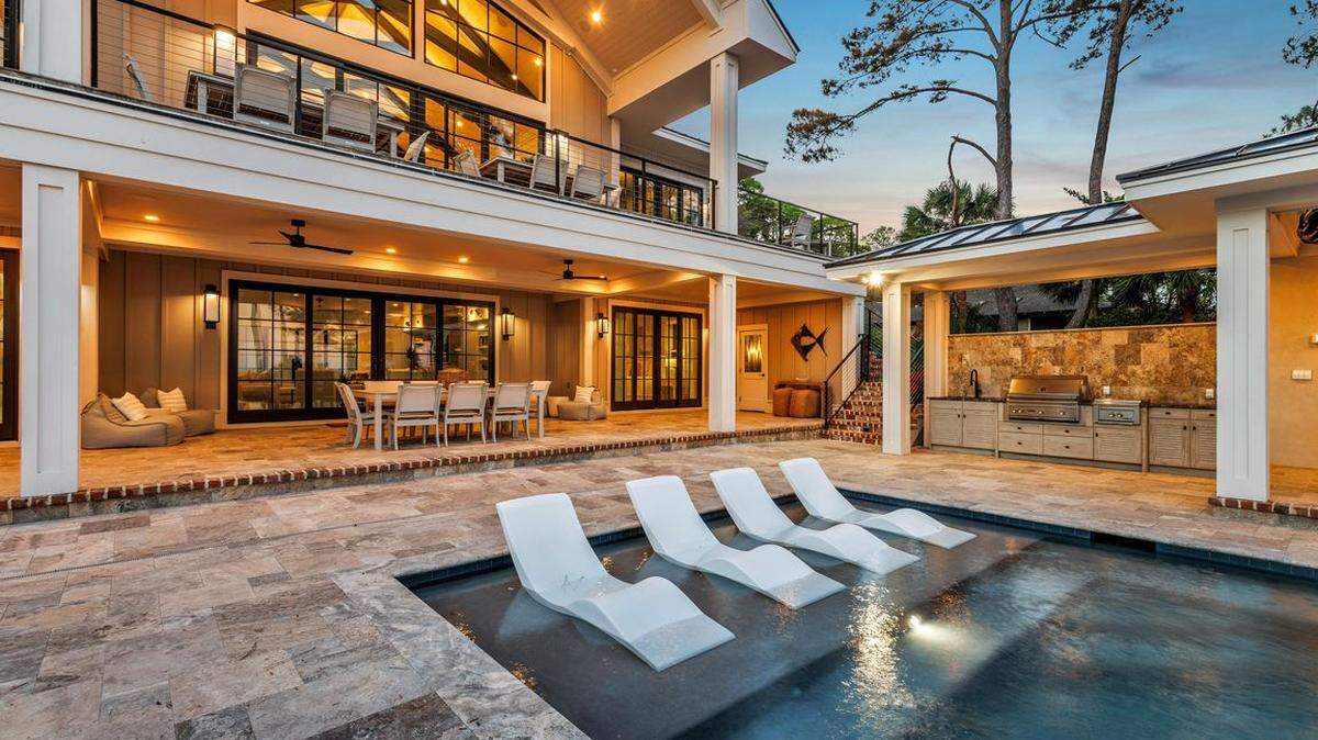 The exterior of the home with the pool and outdoor living space that faces the ocean.