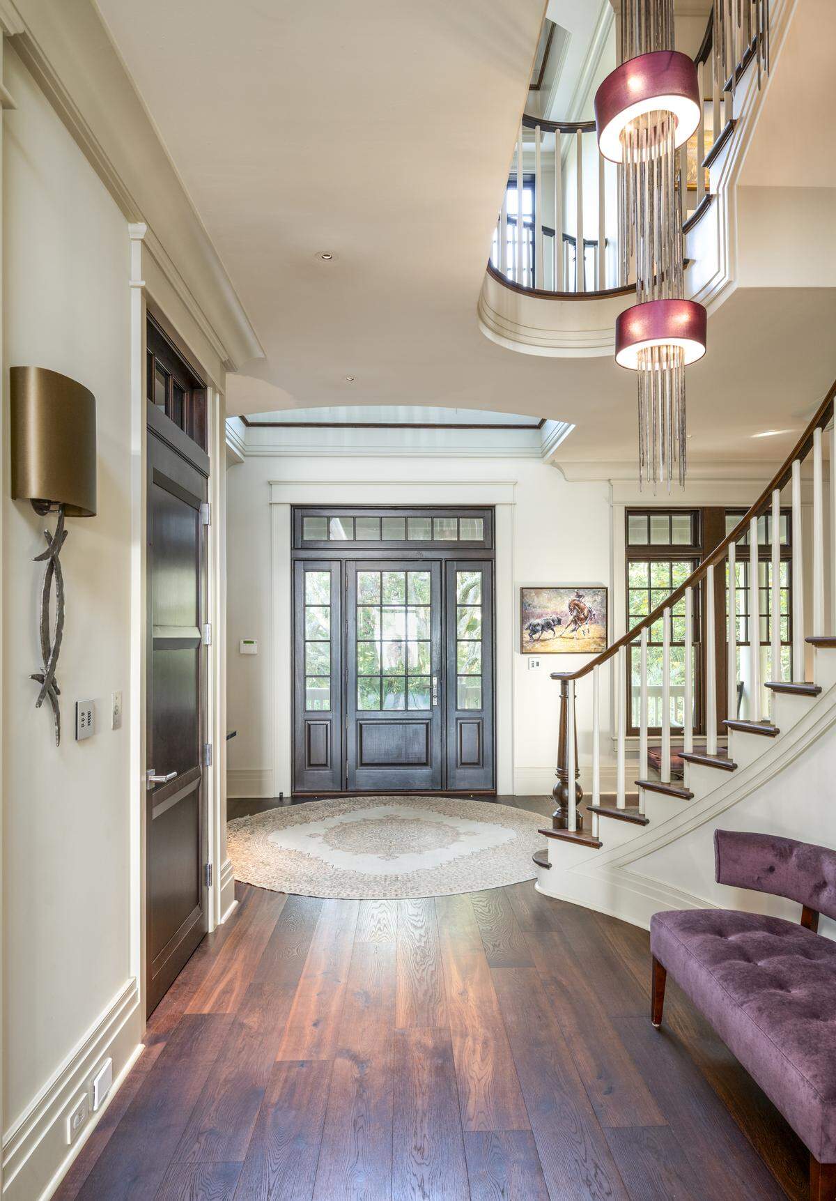 A three-story foyer includes a curved staircase, gallery overlooks and a multi-level chandelier inspired by jellyfish.
