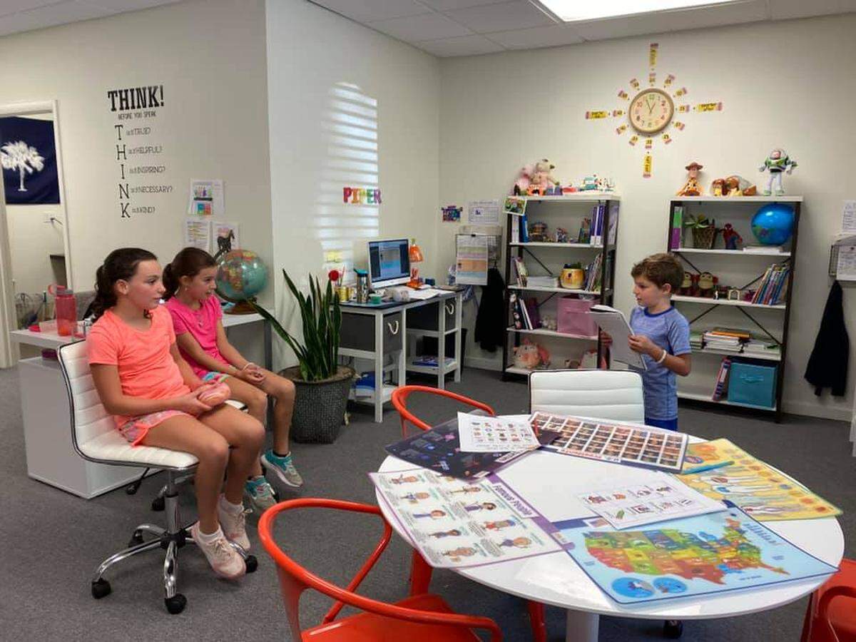 First-grader Renzo Lossada reads sentences he wrote to his sisters at the HHI Learning Club his family set up for school this year.