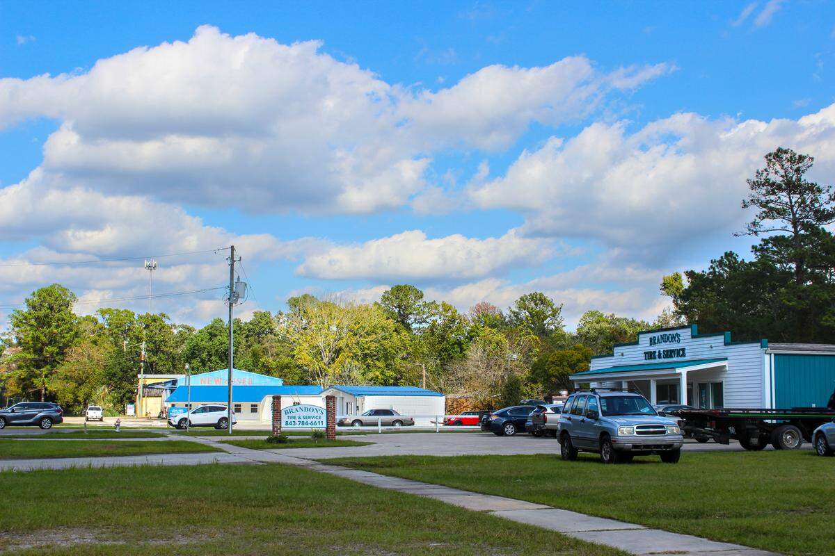 Buildings at the intersection of Whyte Hardee Boulevard and John Smith Road, which eventually leads to the Carolina Station development, include a tire shop and a used car dealership. The intersection has no traffic light. 