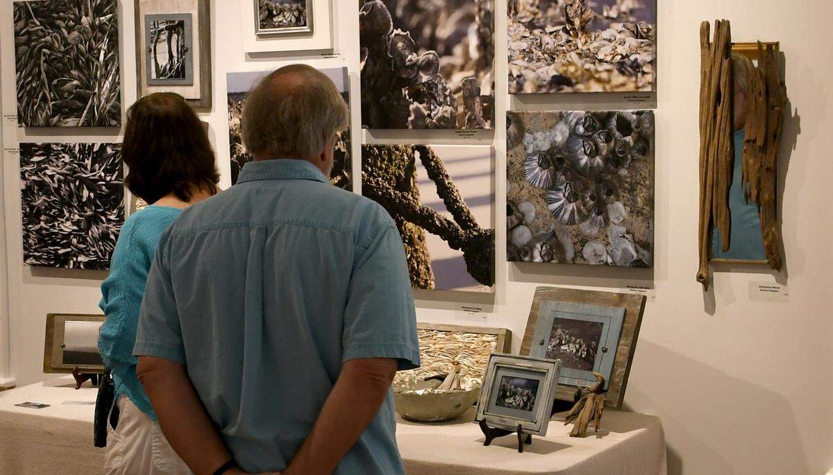 Visitors look at the artwork of Daufuskie Island, S.C. artist Monica Ferguson on Monday morning at the Coastal Discovery Museum at Honey Horn on Hilton Head Island. Ferguson, along with other artists includes a lithograph by musician John Mellencamp - who has a home on Daufuskie - are featured in a temporary exhibit that runs through the end of the year. The artwork entitled, “Sometimes There’s God,” is a limited-edition lithograph that is numbered and signed by the musician and artist, and measures, with the frame, 30 inches by 34 inches.