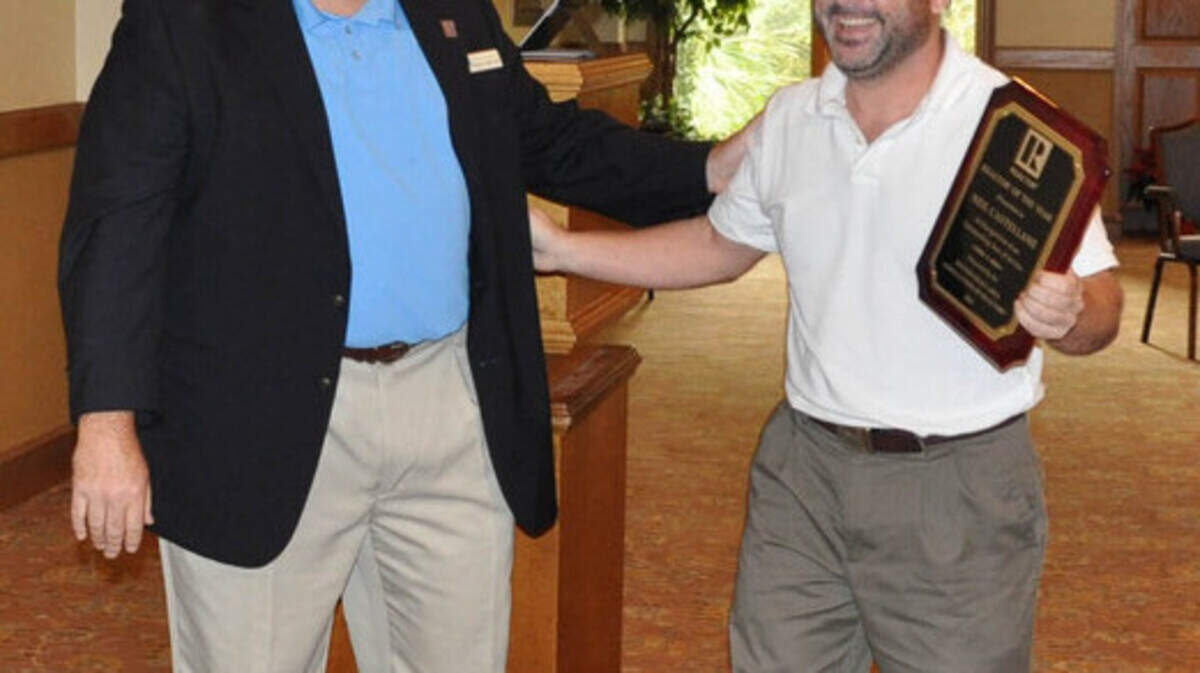 Outgoing association president John Robinson, left, honors Neil Castellane, of William F. Hilton Company, with the Realtor of the Year award. 