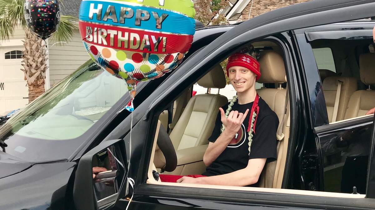 Michael Mugrage, 16, who is fighting a rare form of cancer, sits behind the wheel of a 2006 Ford Explorer given to him by a Bluffton police officer's family for his 16th birthday.