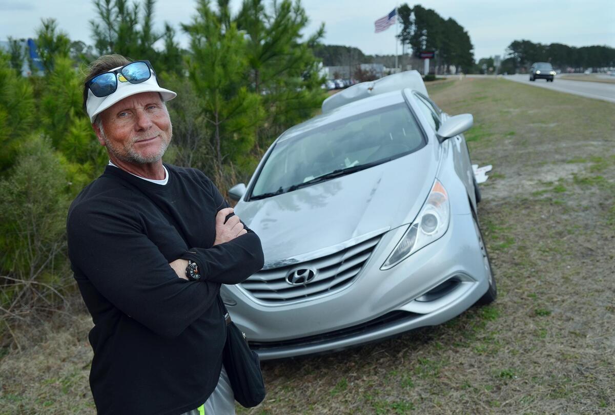 Greg Sanford Hackney is photographed next to his car on the shoulder of U.S. 278 while taking a break from protesting outside Hilton Head Hyundai on Feb. 7. Eight months later, a judge ruled his actions were defamatory and not protected by the First Amendment and ordered a stop to his protest.