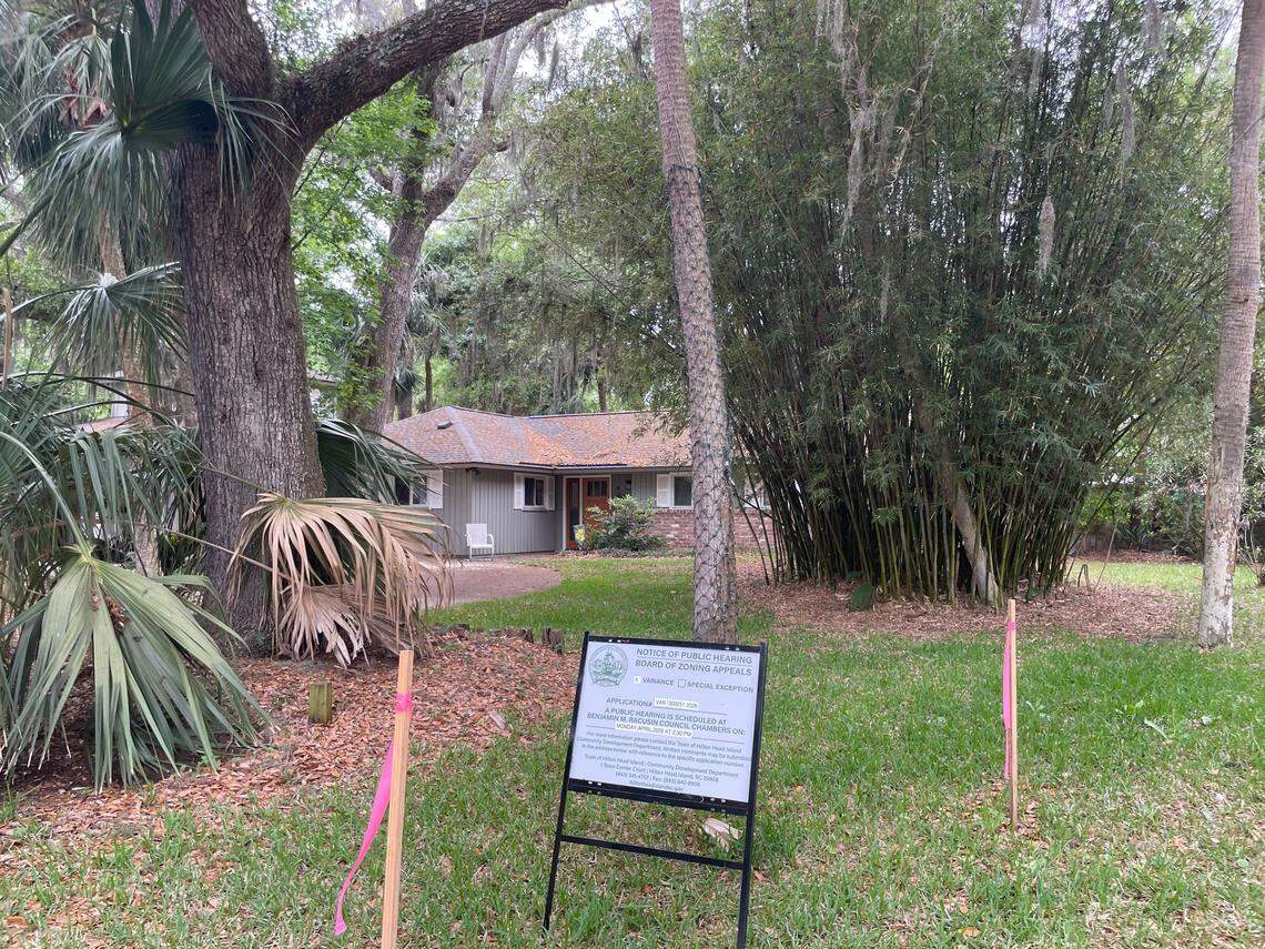 A sign on the Kirchbergs’ property advertises a public hearing for their request for a zoning variance to remove a tree in their backyard.