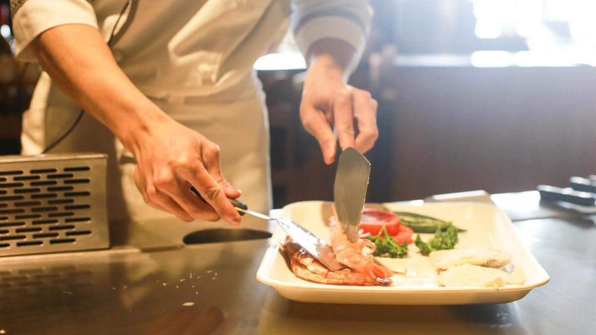 This is a stock image of a chef preparing a plate of food.