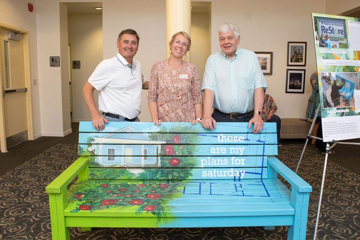 Artist Linda Silk Sviland (center) poses with the bench she painted, which is now located in the Henry C. Chambers Waterfront Park.