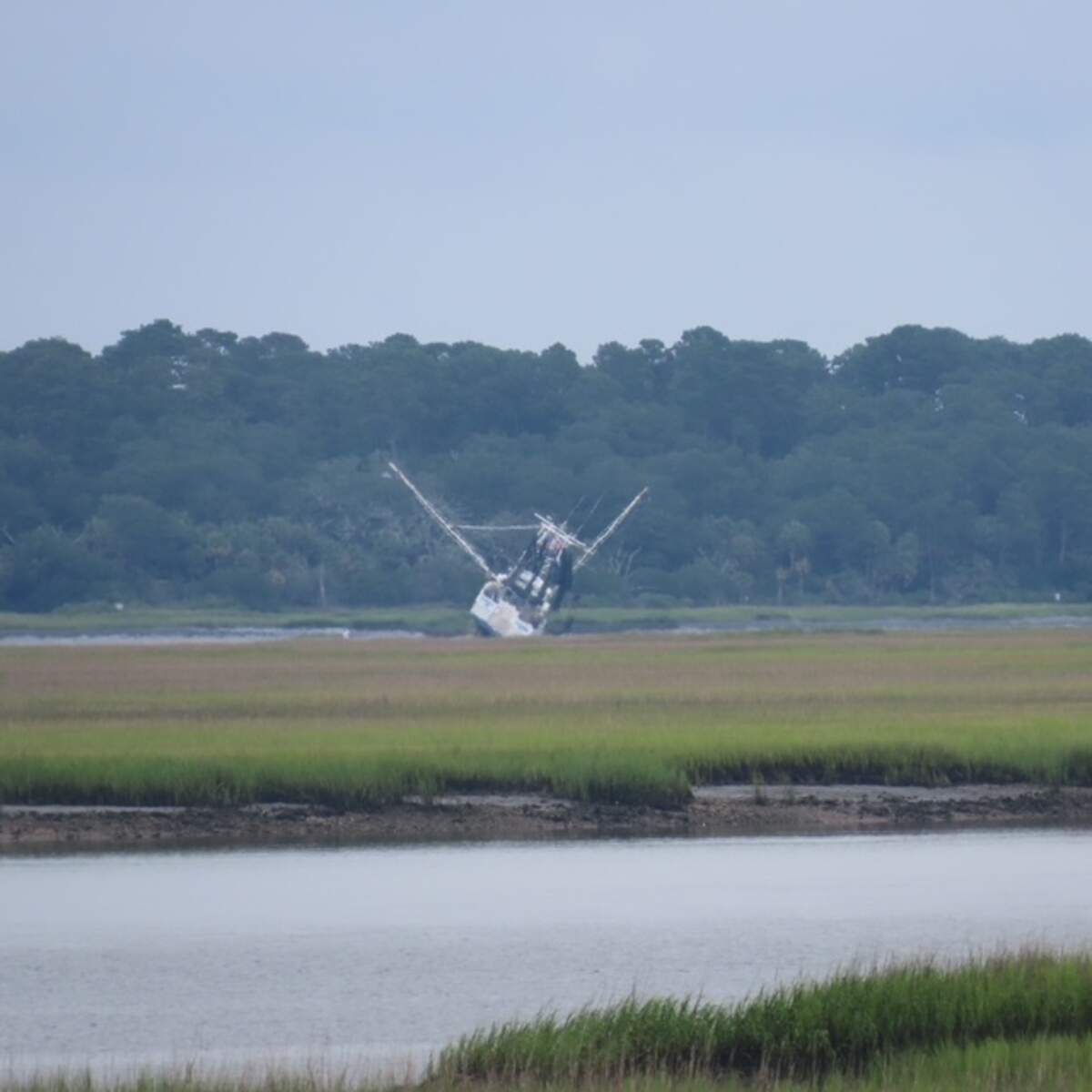 A shrimp boat tilts on a sandbar during low tide on the Morgan River this week.