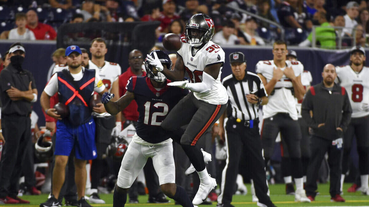 Tampa Bay Buccaneers defensive back Dee Delaney (30) intercepts a pass in front of Houston Texans wide receiver Nico Collins (12) during the first half of an NFL preseason football game Saturday, Aug. 28, 2021, in Houston.