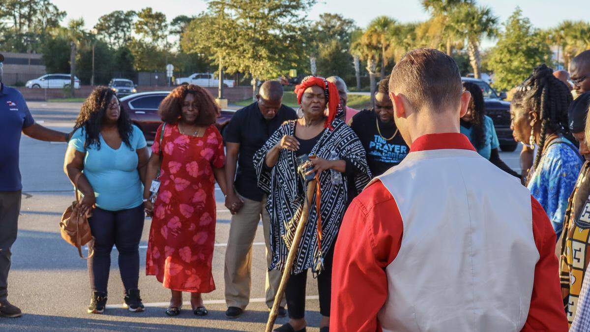 Anita Singleton Prather (center), a Beaufort native and executive director of the Gullah Kinfolk Traveling Theater, leads a chorus of prayer the evening of Oct. 15, 2025, during a gathering to honor the victims of a mass shooting on St. Helena Island.