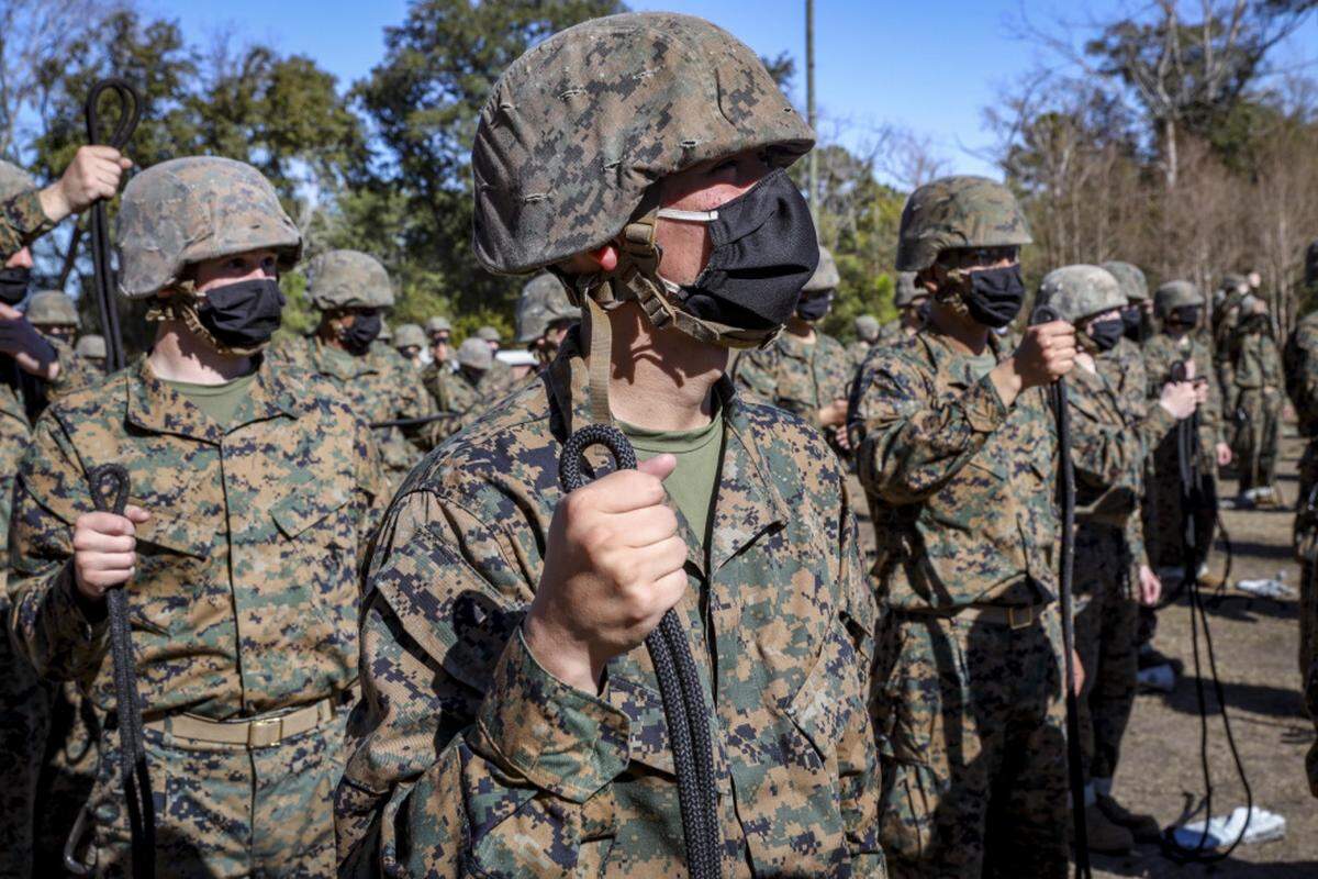 Recruits with Papa Company, 4th Recruit Training Battalion, receive a class before they rappel from the rappel tower at Marine Corps Recruit Depot Parris Island, S.C., Jan. 19, 2021. The rappel tower is used to teach the recruits to overcome fear and trust their equipment.