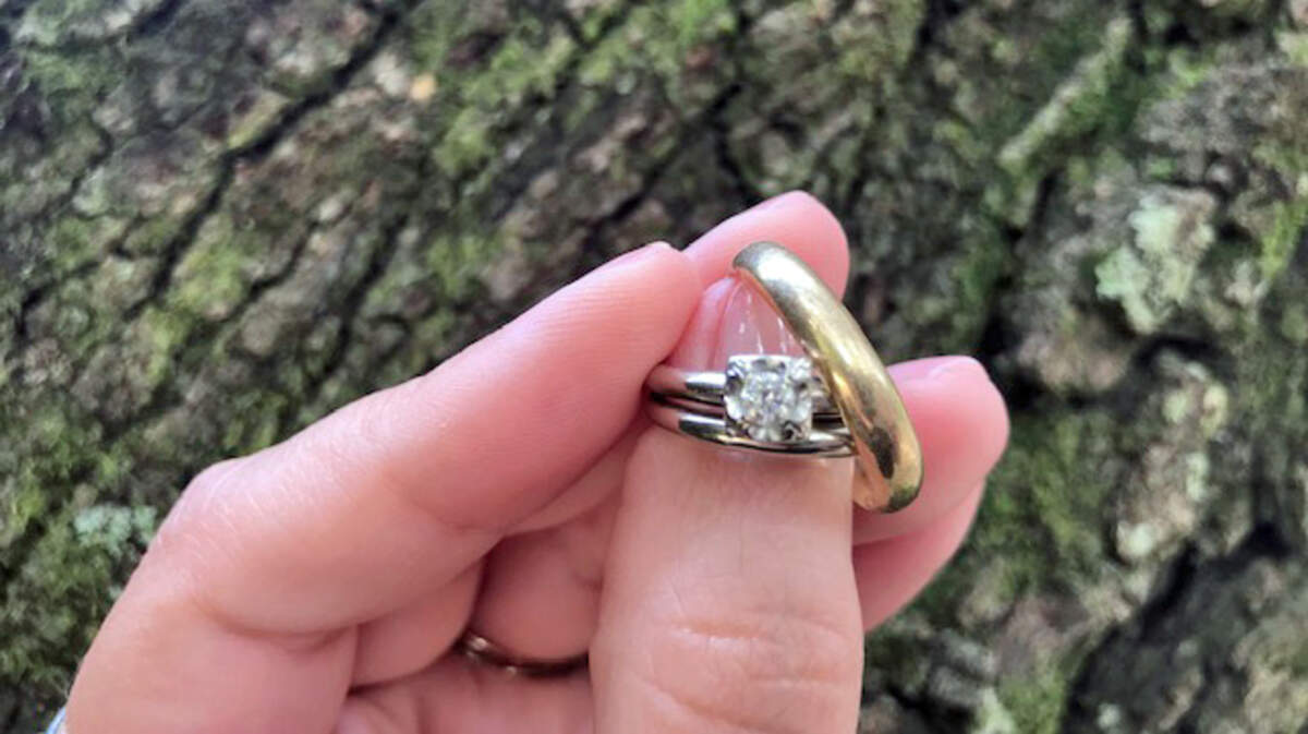 The diamond engagement ring Harry rolled on the table when proposing to Jean is surrounded by their wedding bands.