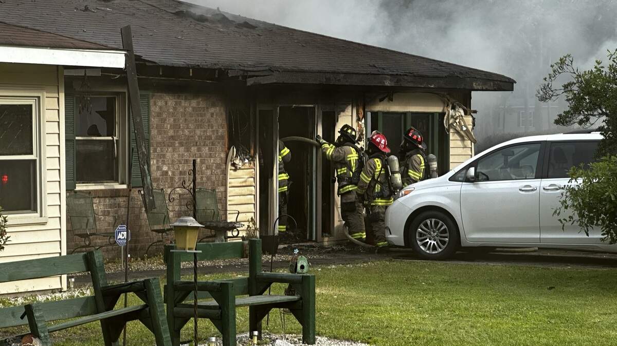 Firefighters work to extinguish the house fire Thursday evening