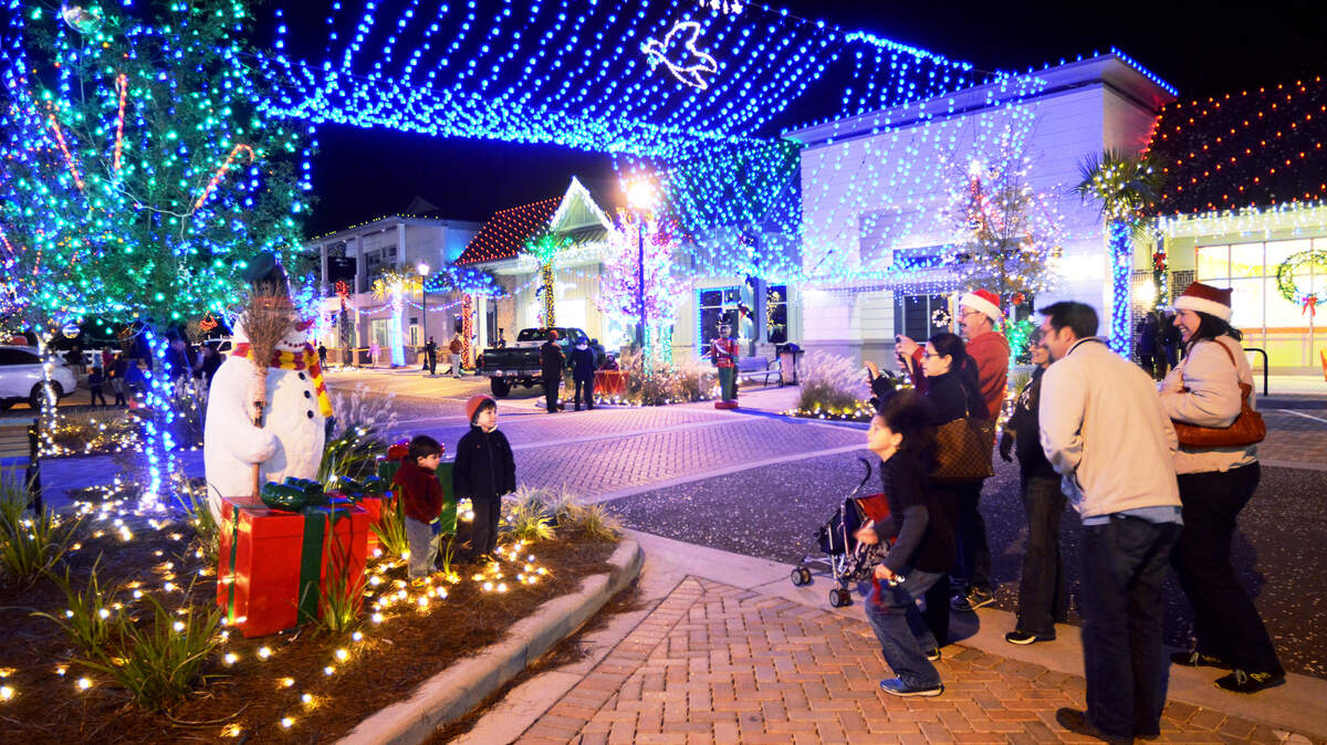 Now: Friends Nico Jackson, 2, left, and Joseph Hood, 3, have their picture taken Dec. 8, 2014, next to a snowman statue after the official public lighting of the Dove Street Festival of Lights, which has been revived and is now located at Shelter Cove Towne Centre. "We're excited," said Joseph's mother, Veronica Hood. "We went to Dove Street for years." Of the new display, she said, "It's not quite tacky enough yet," in reference to the down-home nature of the original Dove Street display. Some 50,000 lights recreate the feel of the community event that drew islanders to Dove Street on North Forest Beach for 20 years before the festival ended in 2010.