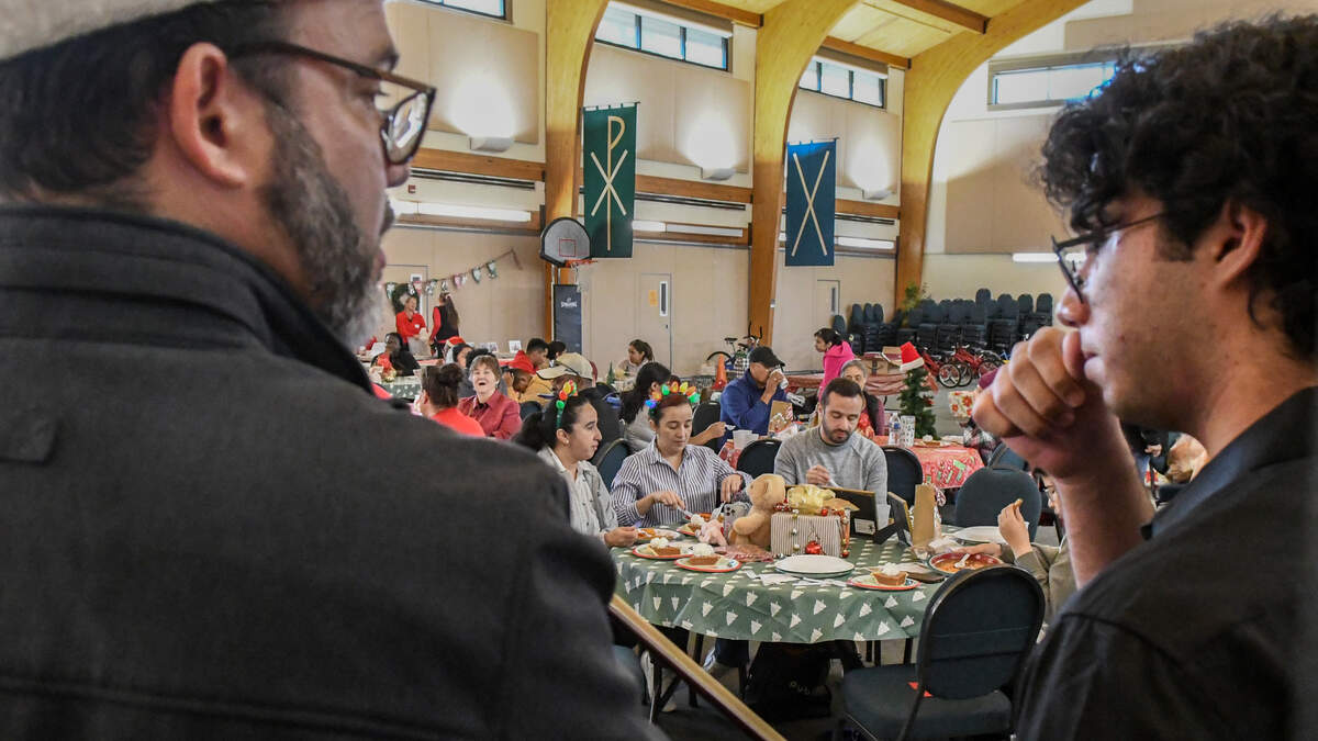 Jesús Parra, left, and his son, Jesús, ponder their next musical selection on Friday, Dec. 20, 2024, after playing their violins to those eating at St. Andrew By-The-Sea United Methodist Church’s Soup Kitchen on Hilton Head Island.