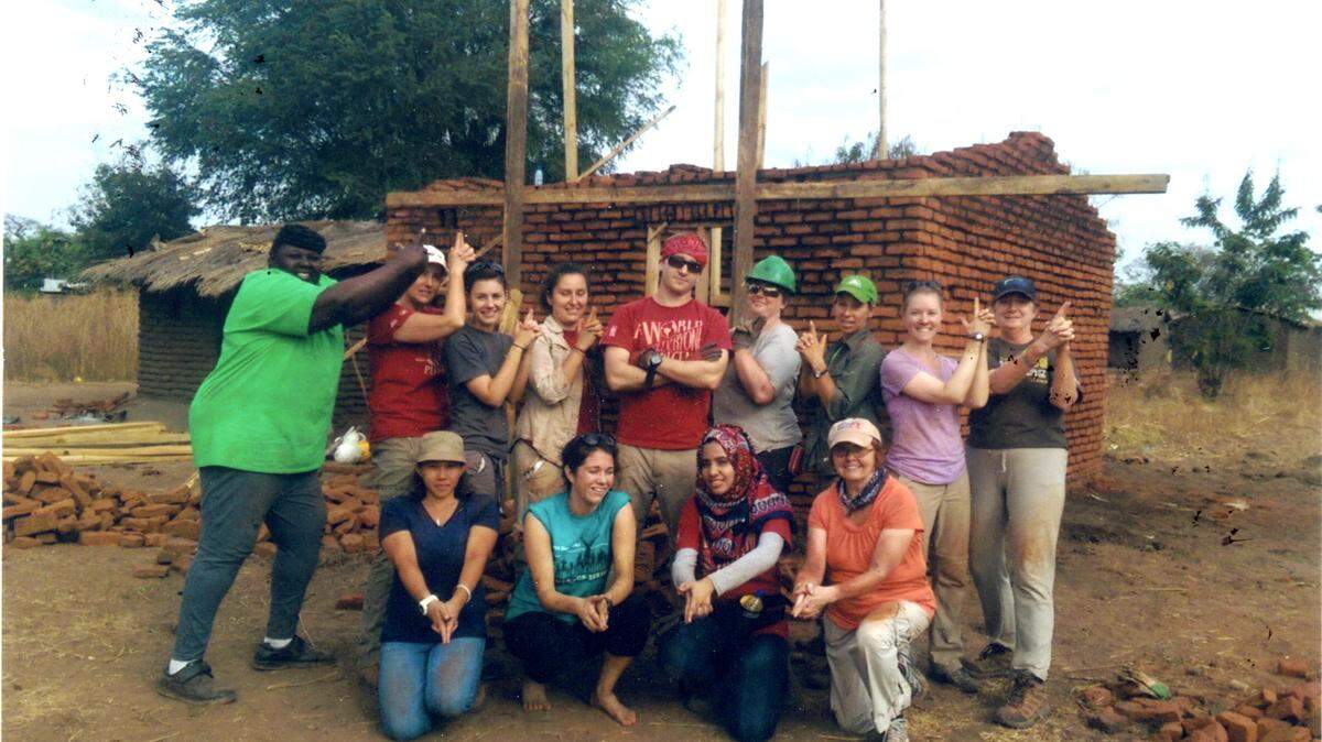Beverly Lawyer Berry stands at far left with the Habitat for Humanity International team building a brick home in Malawi, Africa. They are posing as "Charlie's Angels" because that's what the team called itself.