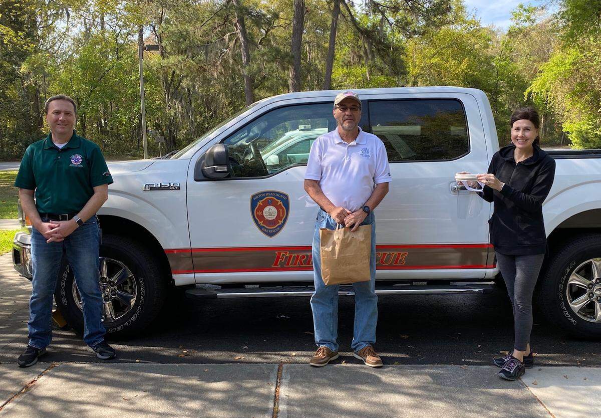 Dr. Len Davidson (center) delivers face shields to Tom Bouthillet of Hilton Head Fire Rescue and Kelly Bouthillet, a local nurse practitioner. The trio maintained safe distance from one another.