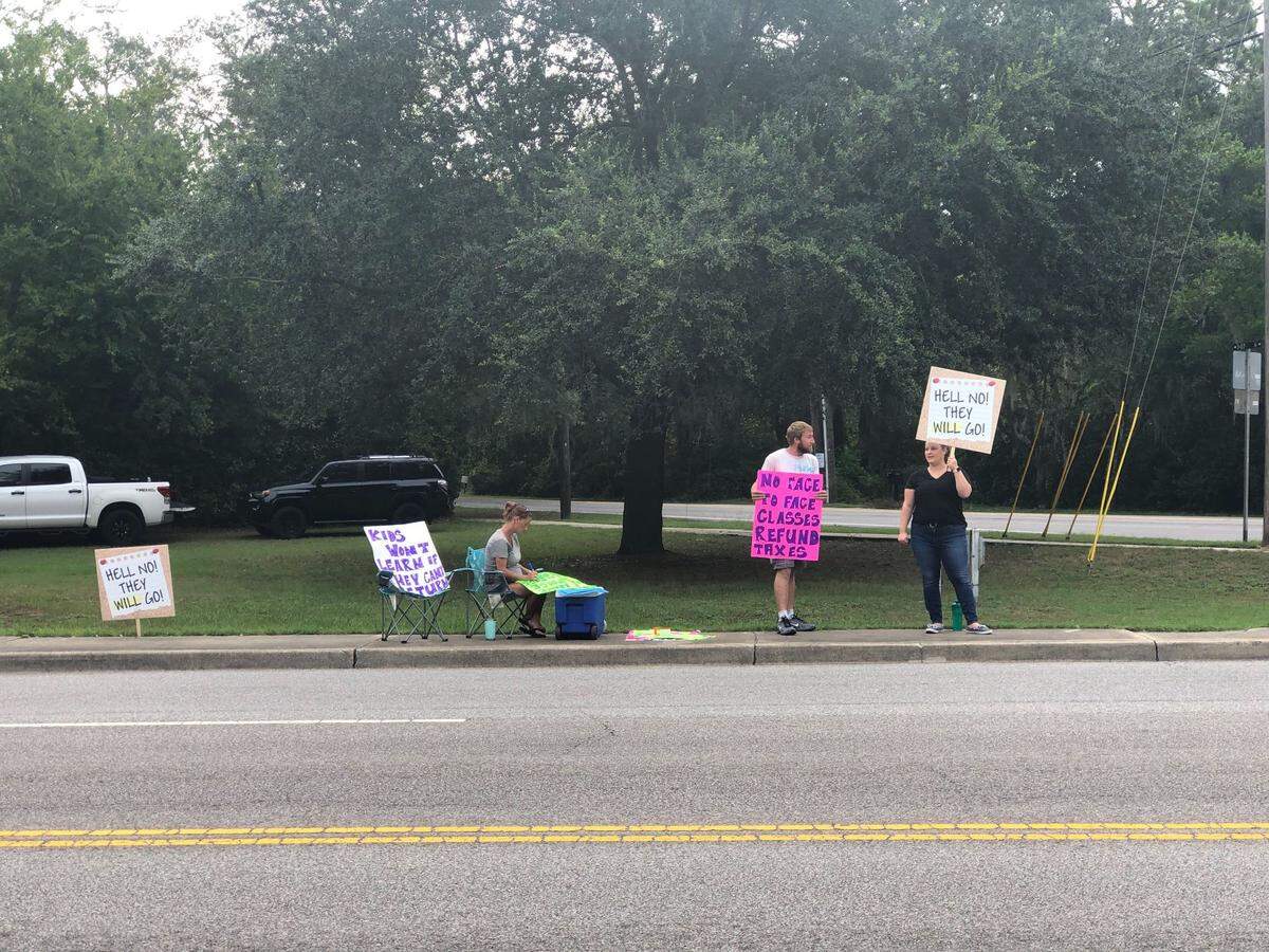 Sean and Devin Apgar hosted a protest in favor of giving parents the option to send their kids back to school Saturday on Ribaut Road near Bay Street.