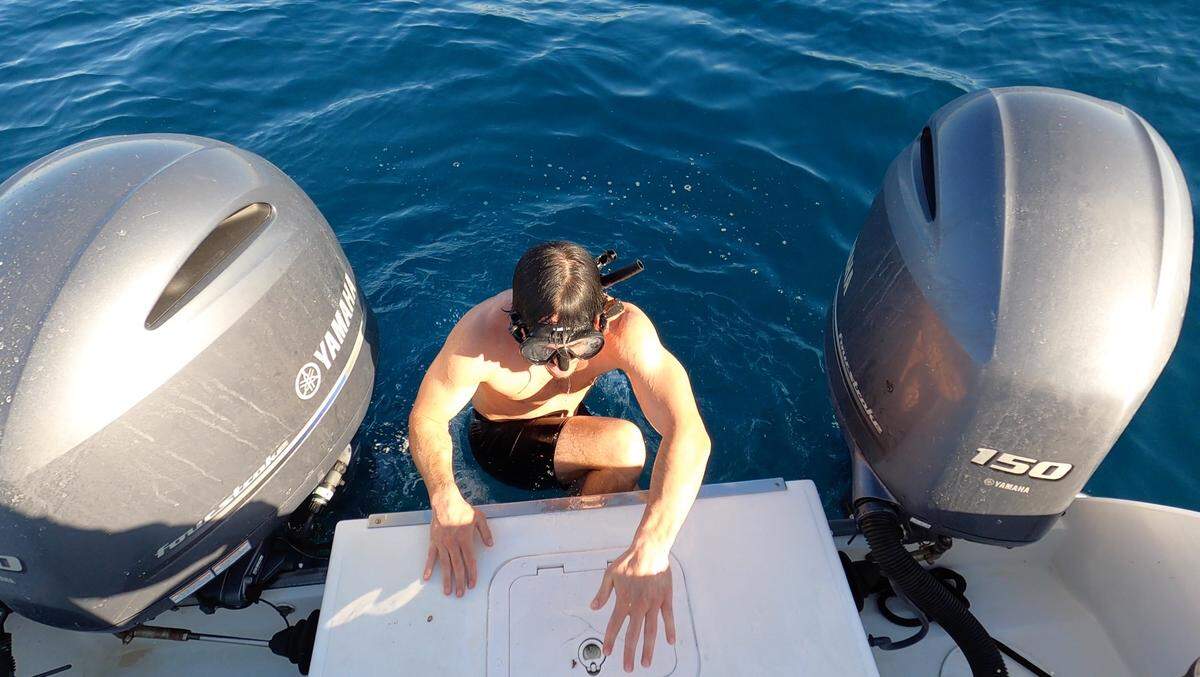 Ben Friedman gets back into the Outcast boat after jumping into the frigid ocean to untangle a line snagged on a barnacle on the boat’s hull Feb. 10, 2022. A 10-foot, 8-inch great white shark was on the other end of the line.