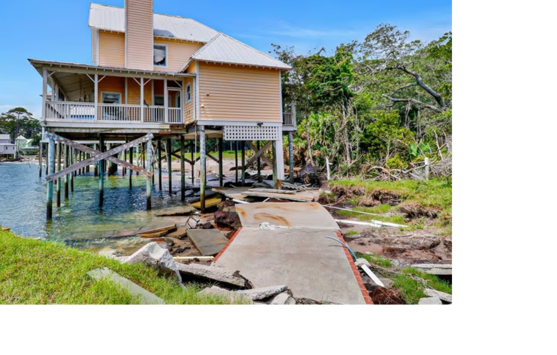 The custom white picket fences, brick-lined driveway, and parking beneath the Daufuskie Island house are all gone due to erosion.