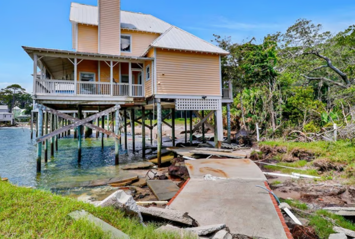 The custom white picket fences, brick-lined driveway, and parking beneath the Daufuskie Island house are all gone due to erosion.