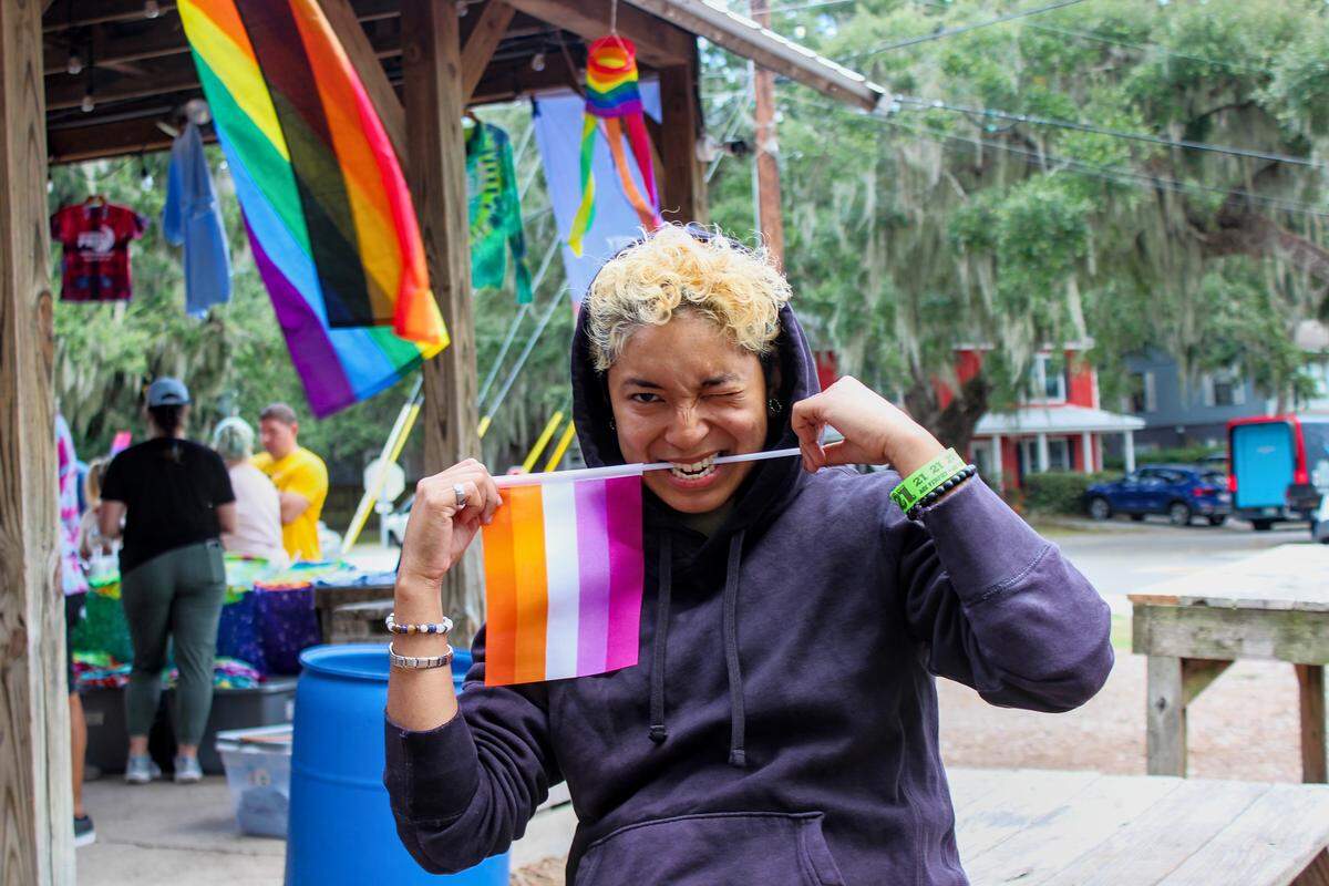 Monica Gates, 27, holds a lesbian pride flag between her teeth. A Beaufort native, Gates said she “sees the divide” over LGBTQ issues in her area. “It’s like you want to fit in but you can’t,” said Gates.