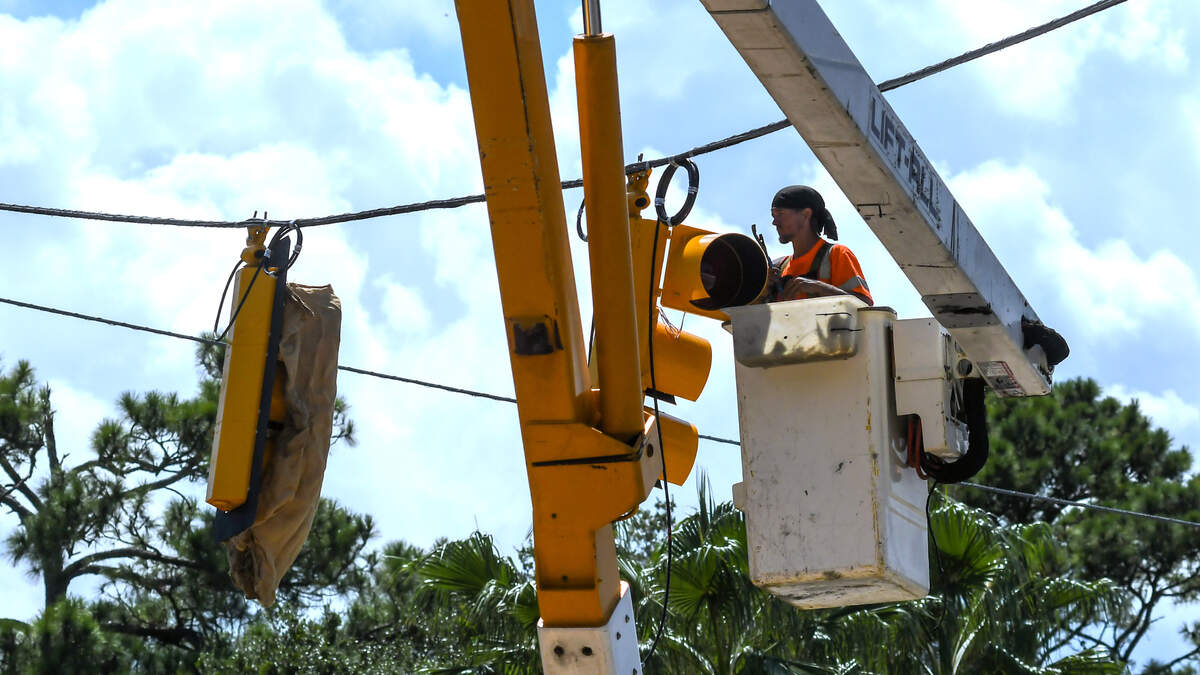 A worker with W.M. Roebuck Inc. installs a traffic signal at the intersection of U.S. 278 at Windmill Harbour on Wednesday, Sept. 13, 2023, on Jenkins Island. According to a Beaufort County notice posted on Sept. 8, the installation is expected to be finished in three weeks. The temporary wood poles will be replaced with mast arms and signaling software the Town of Hilton Head Island is currently using when the US 278 Corridor Project gets underway.