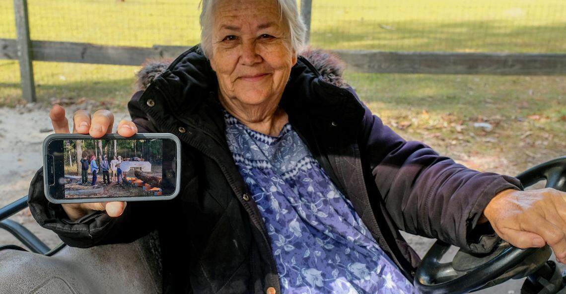 Pat Beichler shows a photo of the original sawmill they used in the past to turn downed trees into slabs and boards at the Daufuskie Community Farm on Dec. 6, 2021 on Daufuskie Island. Beichler has rented the land annually for a dollar in a 10-year contract, that has since expired, is trying to raise the $236,000 to buy the 8-acre site. Beichler and her associates are trying to morph the farm into an artisan village where islanders and visitors can lean about pottery and wood working, blacksmithing as well as continue basic farm chores like milking goats or collecting chicken eggs.