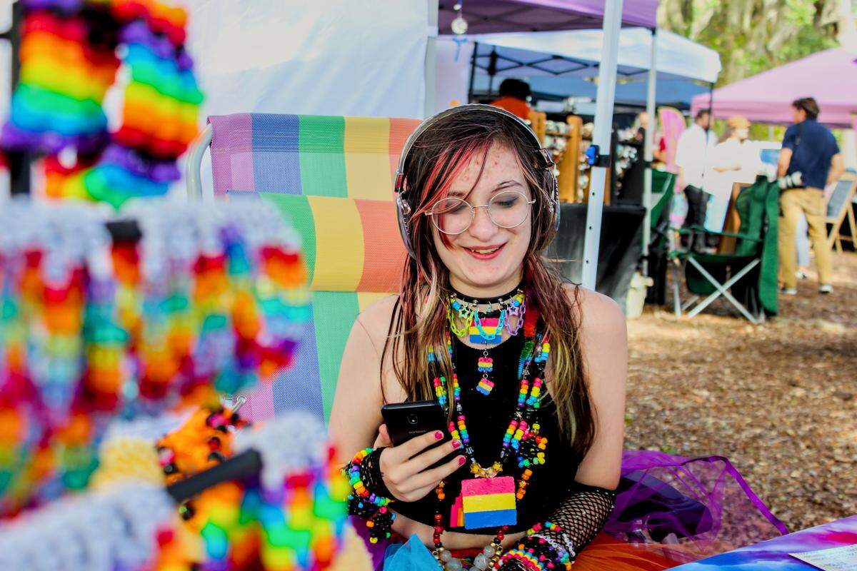 Local teen Vivienne Yates sells rainbow beaded bracelets while donning several pieces of her own jewelry necklaces that feature the colors of the pansexual pride flag. Yates calls her jewelry “Ultraviolet Kandi”.