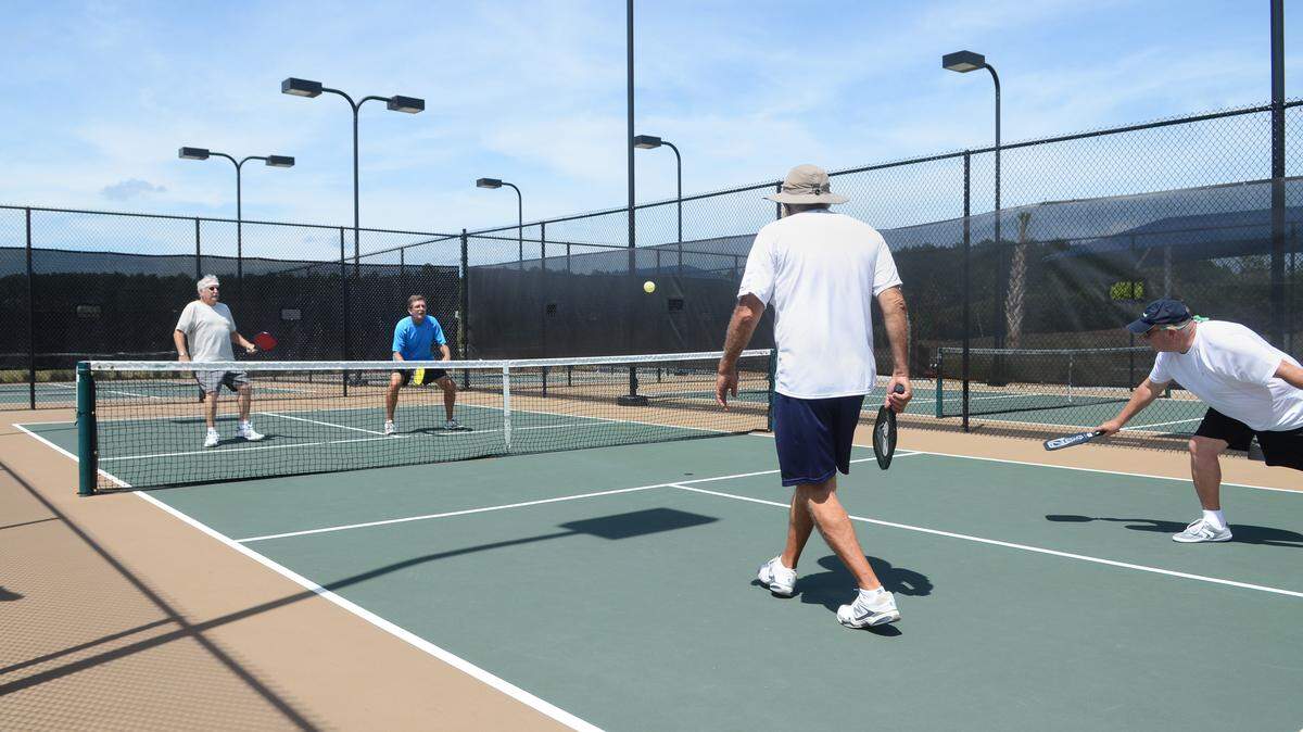 Pickleball is played by four players and, at 20 by 44 feet, a pickleball court resembles a miniature tennis court.
