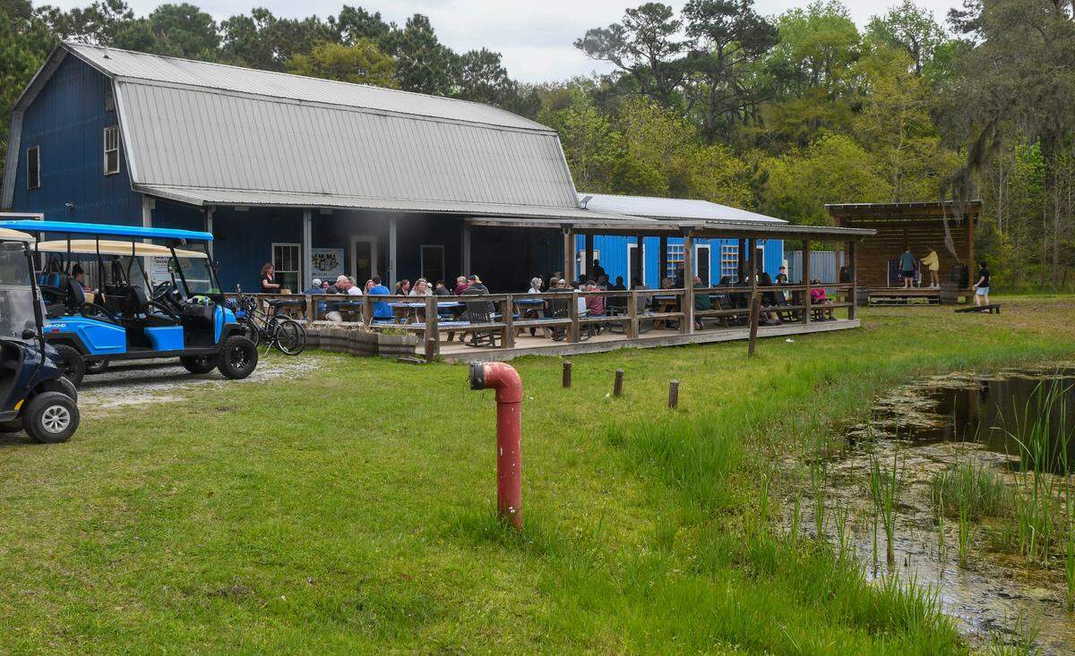A view of the Daufuskie Island Distillery with outdoor seating photographed on Tuesday, March 26, 2024 on Daufuskie Island. The owners have doubled the size of the distillery, right of the barn structure, which is expected to be completed soon.