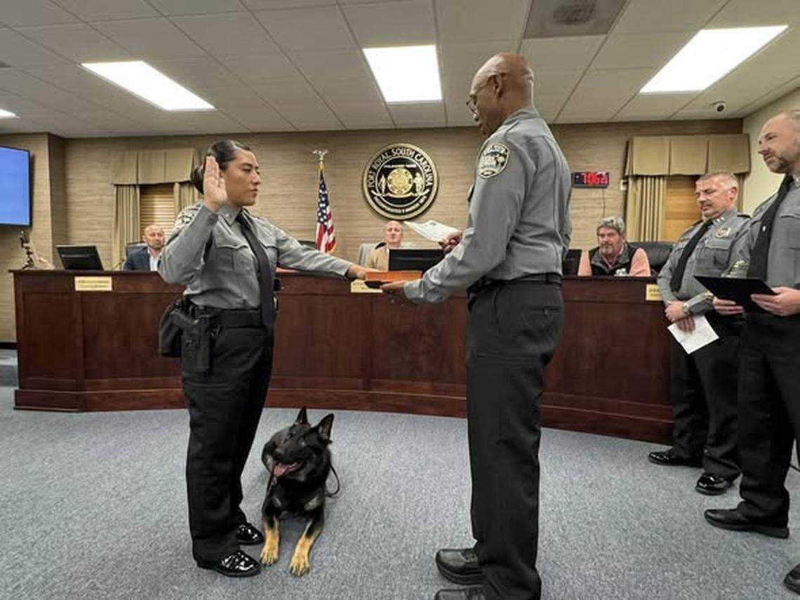 Chaplin Daniel Russell swears in Cpl. Karina Galindo and her new partner, Rocky, a 1 1/2-year-old German shepherd.
