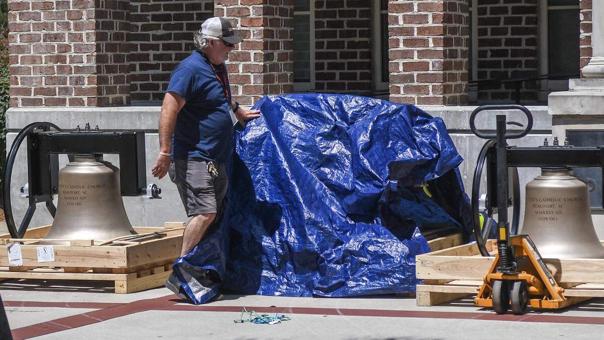 Brian Wegman, a member of St. Peter’s Catholic Church’s maintenance staff, covers the bells on May 19, 2026, to protect them overnight. The bells were installed with a 165-ton crane the next day.