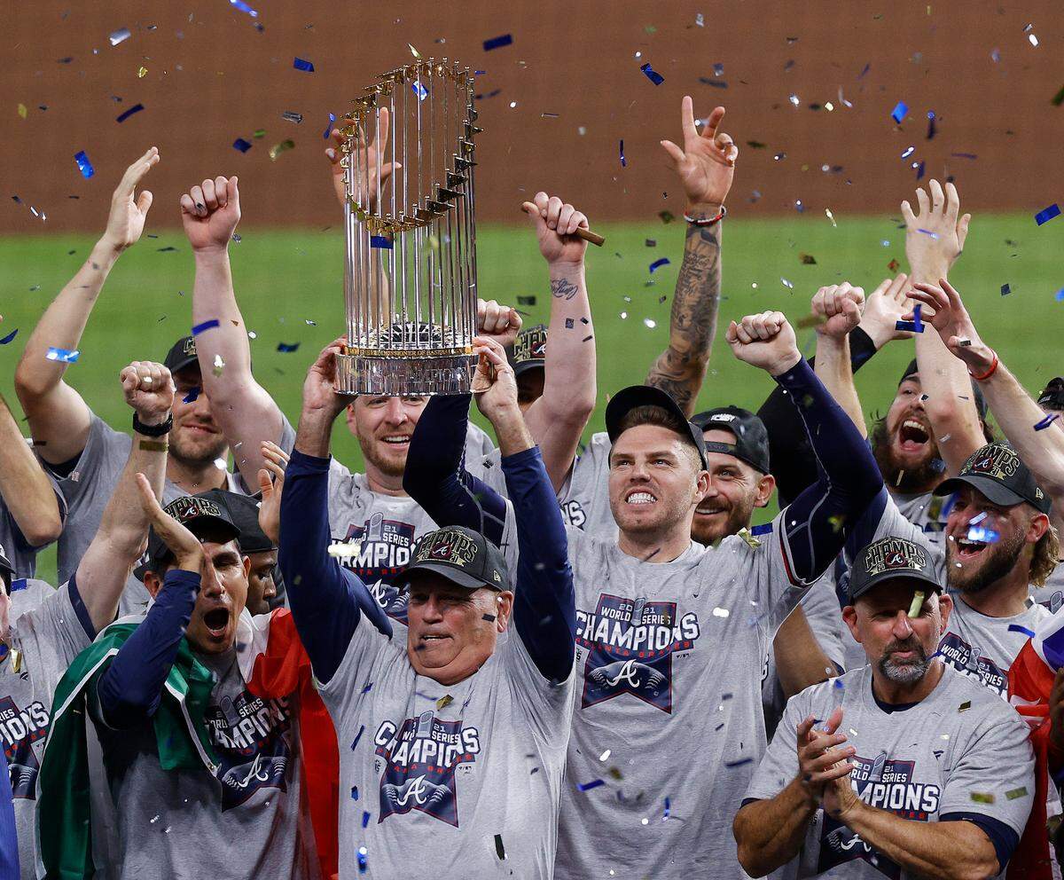 Atlanta Braves manager Brian Snitker hoists the trophy as first baseman Freddie Freeman cheers after the Braves won the baseball World Series with a win over the Houston Astros in Game 6 of the series, Tuesday, Nov. 2, 2021, in Houston.