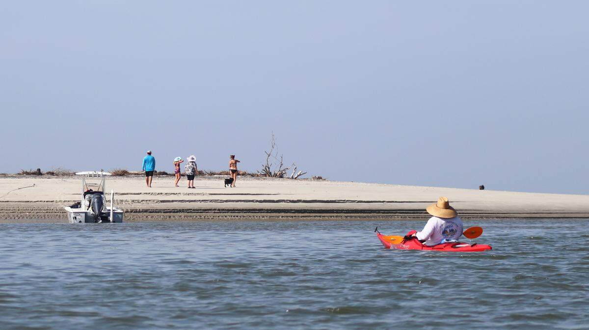 Beaching, a Lowcountry pastime, is one of the activities that often occurs on the sandy point of Capers Island. Here Brian Pennell of Bluffton kayaks to shore on this remote island where a family has already stopped to enjoy a walk on the beach.