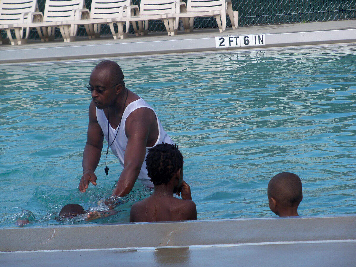 Alvin Settles teaches children to swim at the Greene Street Swimming Pool in downtown Beaufort. Settles died in April 2021. The pool has been renamed in his honor as the Alvin Settles Pool.