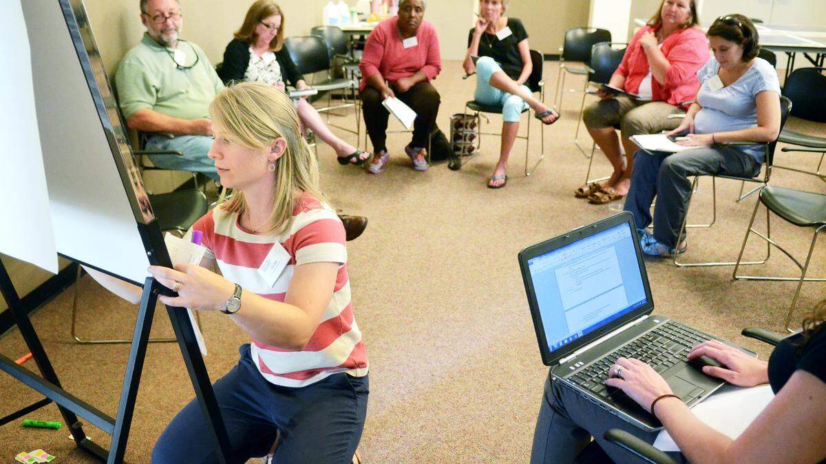 Elizabeth Fly, foreground, a coastal climate extension specialist with the S.C. Sea Grant Consortium, writes down strategies for adapting to sea level rise suggested by her breakout group during a free public workshop held at the Bluffton Branch of the Beaufort County Library on Monday. Participants discussed the latest science on sea level rise, local vulnerabilities that were identified by Beaufort County staff and local stakeholders, and brainstormed possible adaptation strategies to use in writing an action plan for Beaufort County.