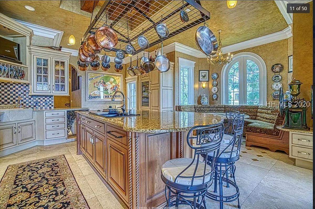 The kitchen at a home in Wexford on Hilton Head Island listed for $12.5 million. It includes a fireplace, Viking Professional six burner gas cooktop plus two grill cooktops and double ovens. It has a built-in Miele coffee/cappuccino&nbsp;machine, microwave convection oven, warming drawer, Subzero 78-bottle wine fridge, two fridge drawers, walk in pantry, two dishwashers, farmhouse sink, and Kohler Pro-Cooker dual-purpose sink.