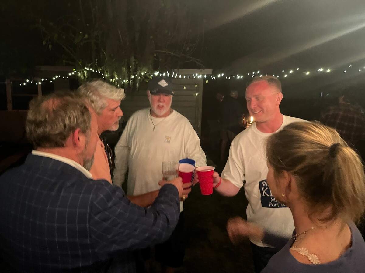 Kevin Phillips, second from right, shares a toast with supporters after winning the mayor’s job in Port Royal, based on unofficial results. “I’m sunburned, dirty and exhausted, but couldn’t be happier,” Phillips said.