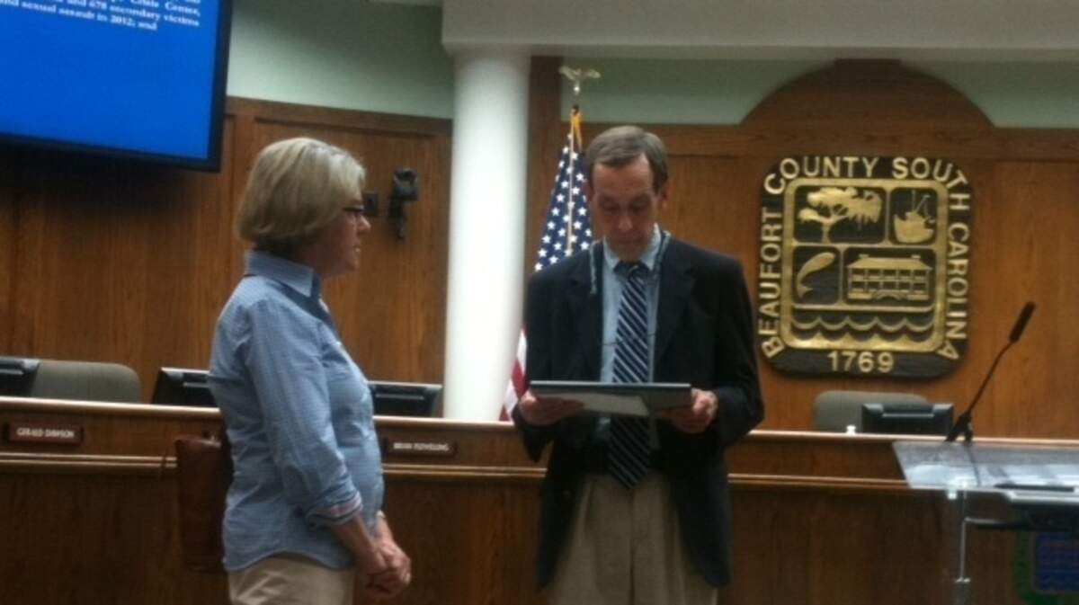 At Monday's council meeting, a representative of Hope Haven looks on as County Council Chairman reads  a proclamation naming April Sexual Assault Awareness and Prevention  Month and Child Abuse Prevention Month.