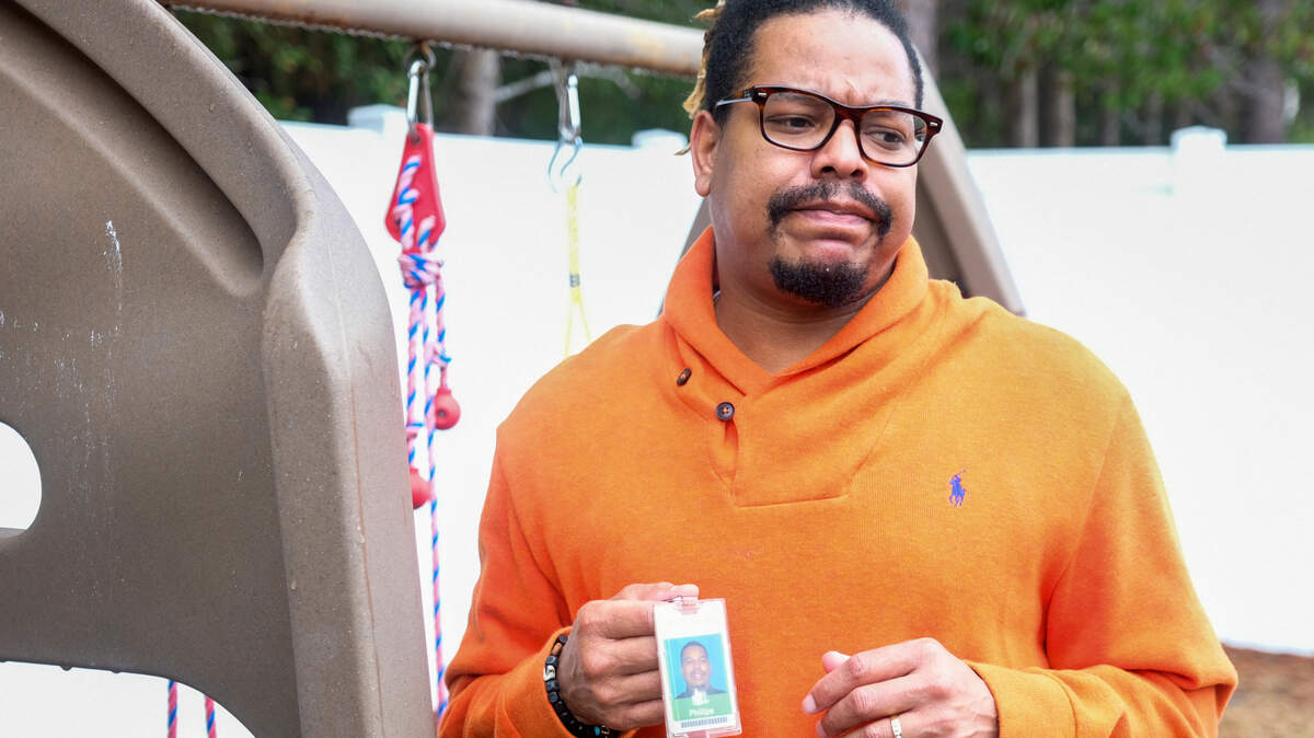 With no computer and locked out of his district account, Qaadir Phillips ponders a question on Wednesday, Feb. 10, 2021 while holding his Beaufort County School District employee badge, the last remnant of working for the district.