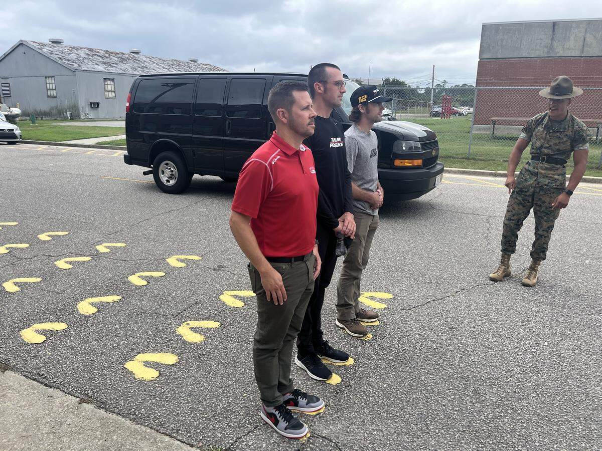 From left to right, Josh Harris, president of Darlington Raceway, and professional stock car racing drivers Austin Cindric and Ryan Blaney are welcomed to U.S. Marine Corps Recruit Station Parris Island by Sgt. Sakiya Phillips, a drill instructor. As all recruits do when they arrive, they stood in the iconic yellow footprints.