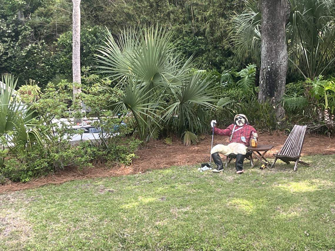 With a bottle in one hand and a club in the other, a spectator watches the RBC Heritage during Plaid Nation Saturday.